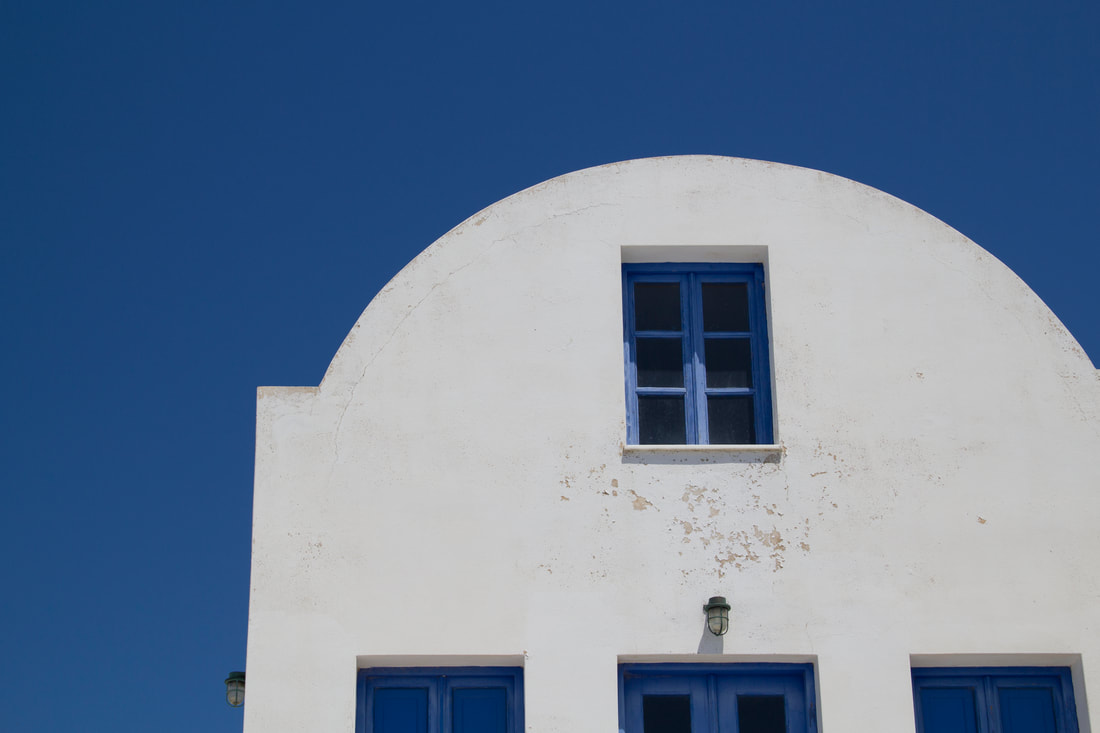 White building with blue window in front of the blude sky