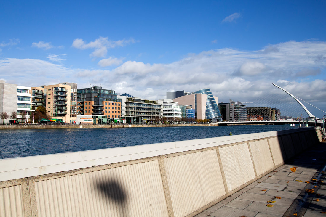 Modern buildings next to the riverside with a bridge in the far end