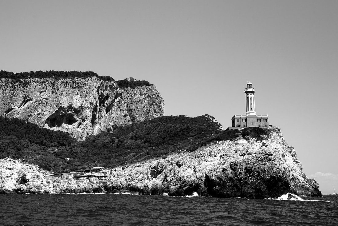 Light house on the side of the cliff of an rocky island