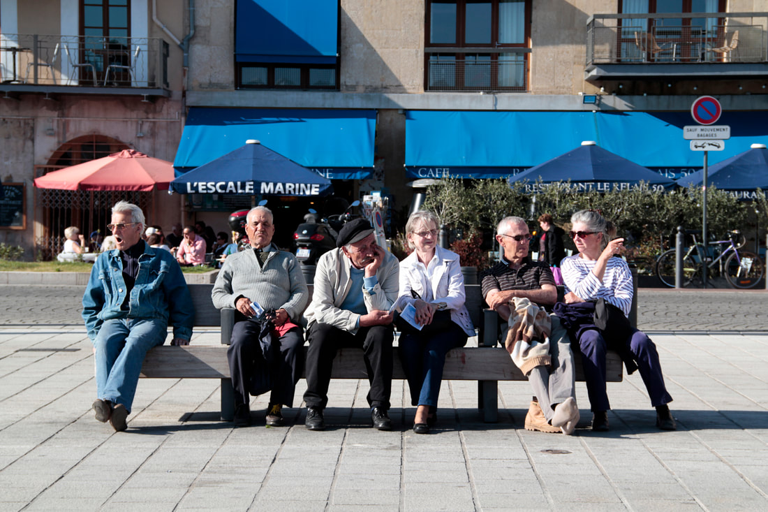 Old people sitting on the bench at the port of Marseille.