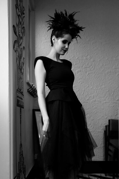 Female model with black dress and feather hair pieces 