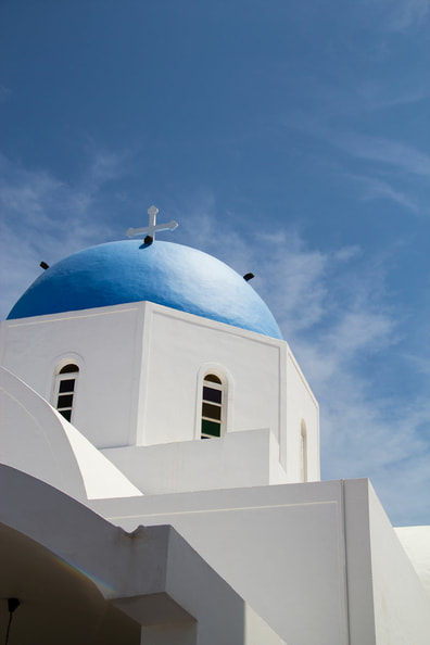 A church with white washed wall and blue dome