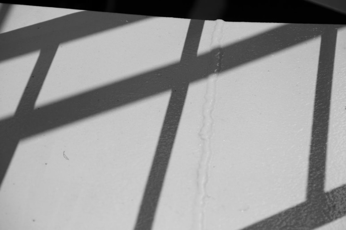 Shadow create by balustrade lies on the white wall.
