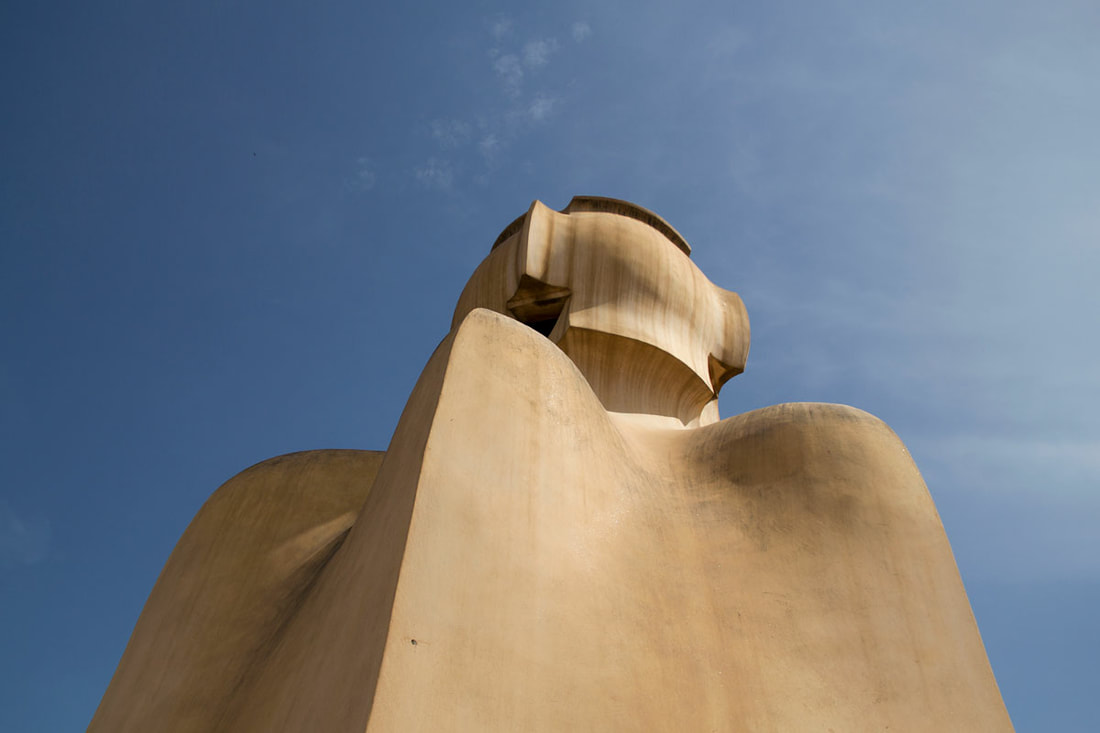 A human look camel colour sculpture of Antoni Gaudí in front of blue sky. 