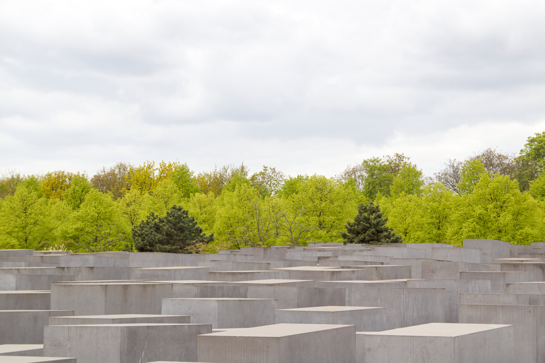 Stelae of Memorial to the Murdered Jews of Europe with trees in the back.